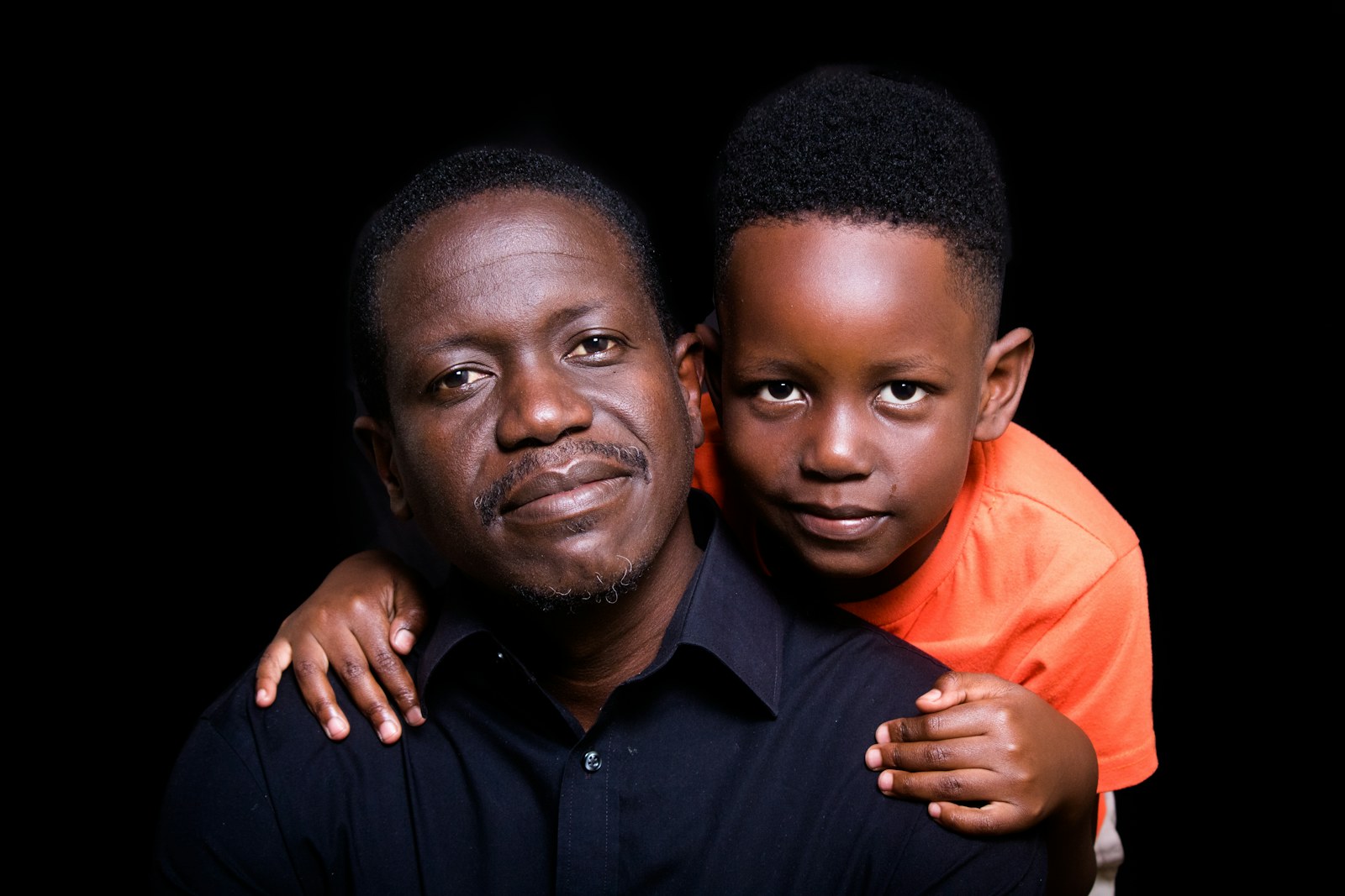 A Zimbabwean father and his young son standing together outdoors
