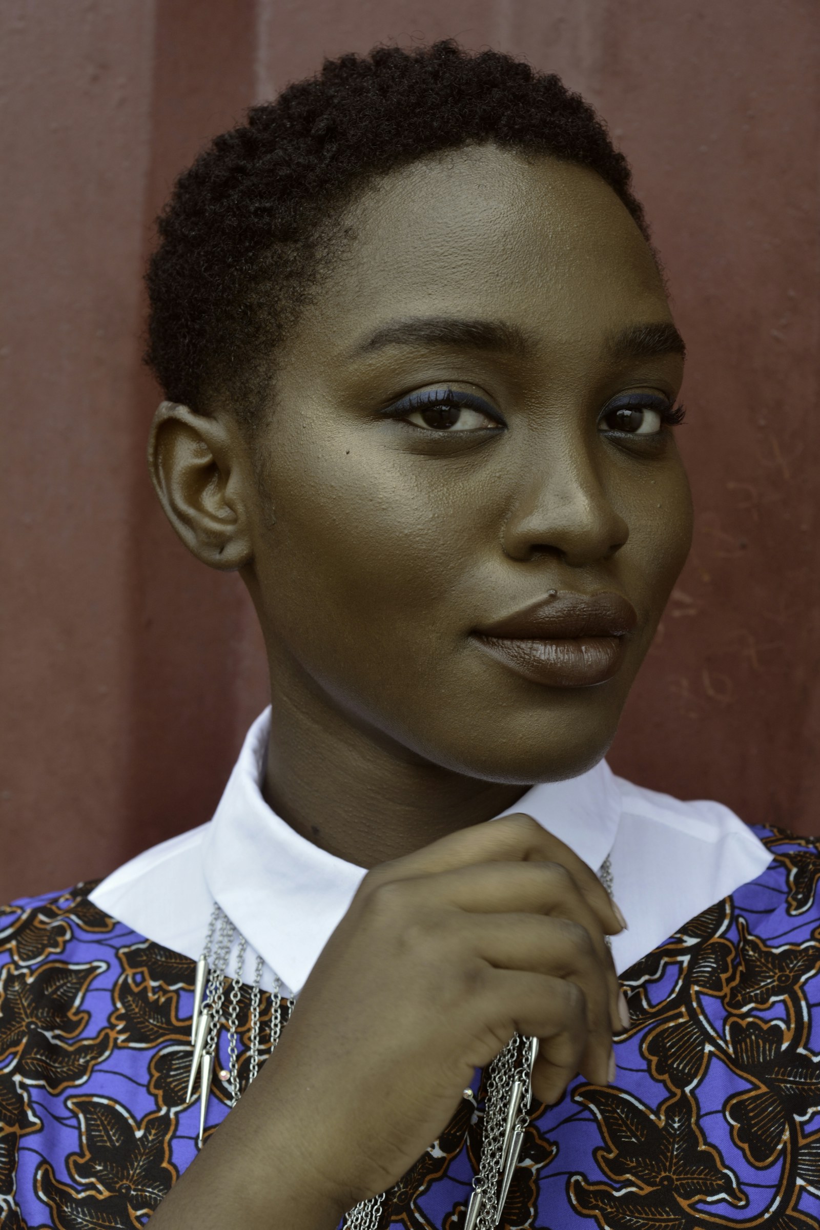 Portrait of a confident Black woman in a patterned blue top